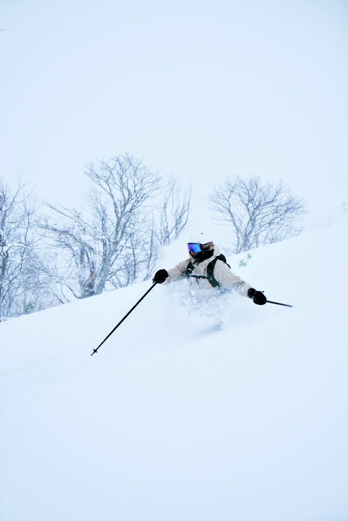 Skier carving through deep powder in Japan
