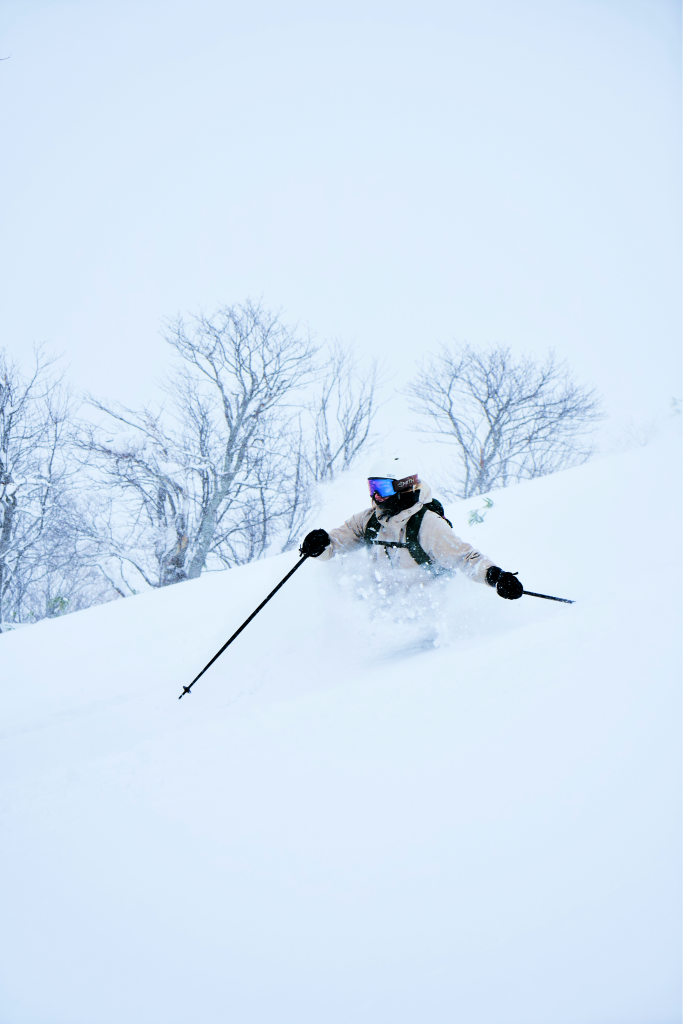 Skier carving through deep powder in Japan