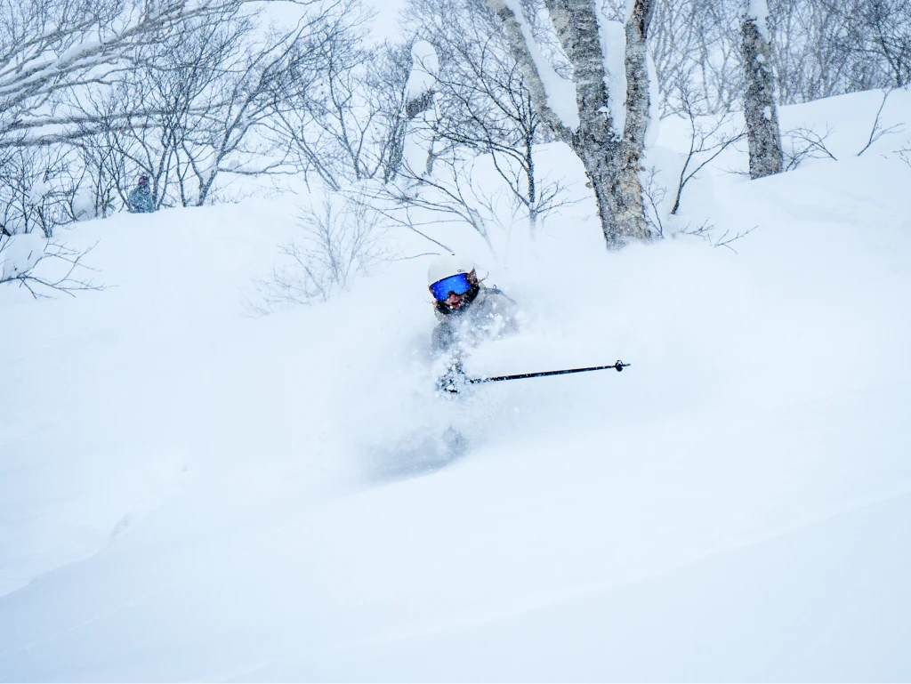 Skier riding through deep powder in Japan