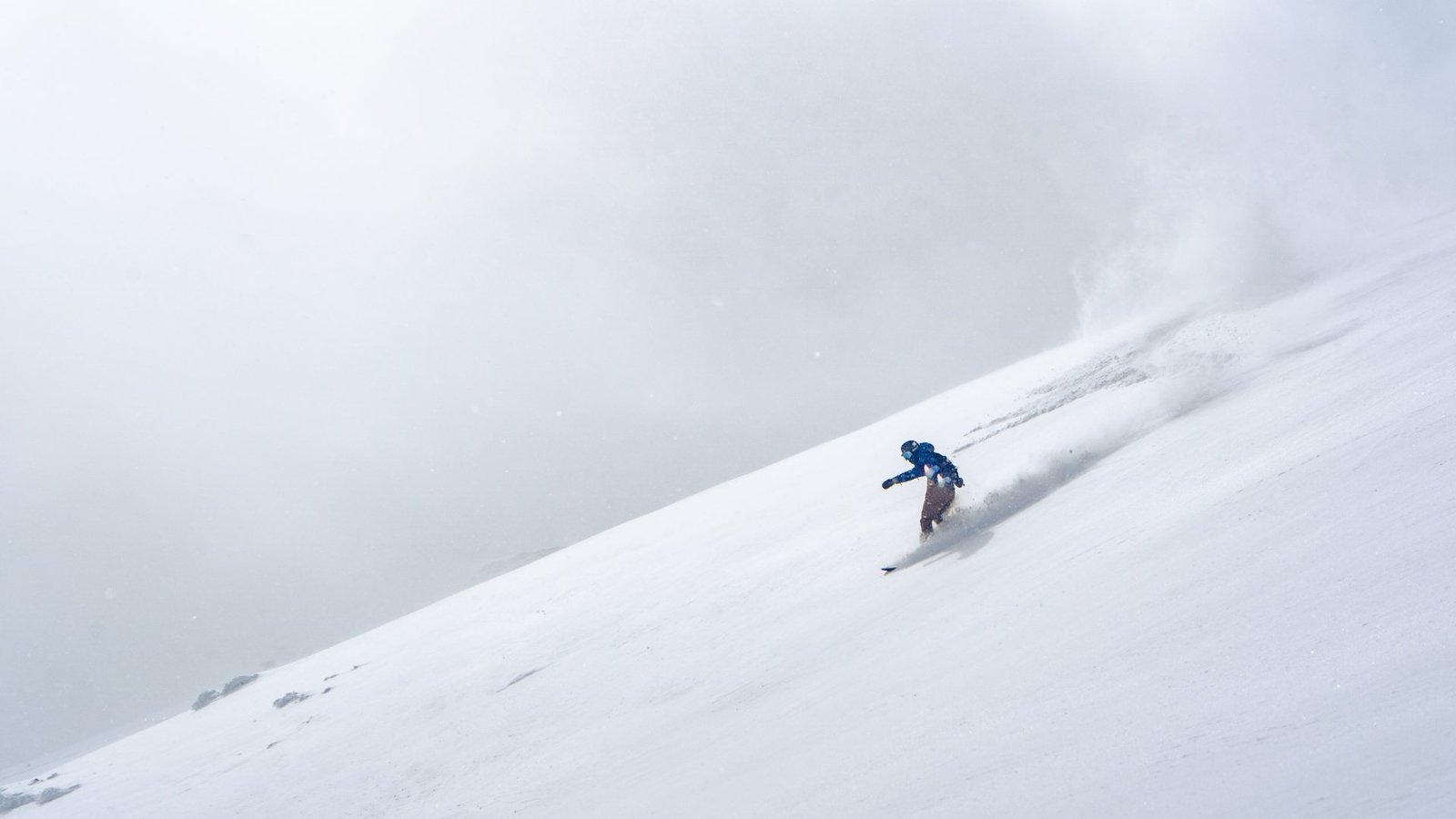 Skier crossing a wide Japanese powder slope.